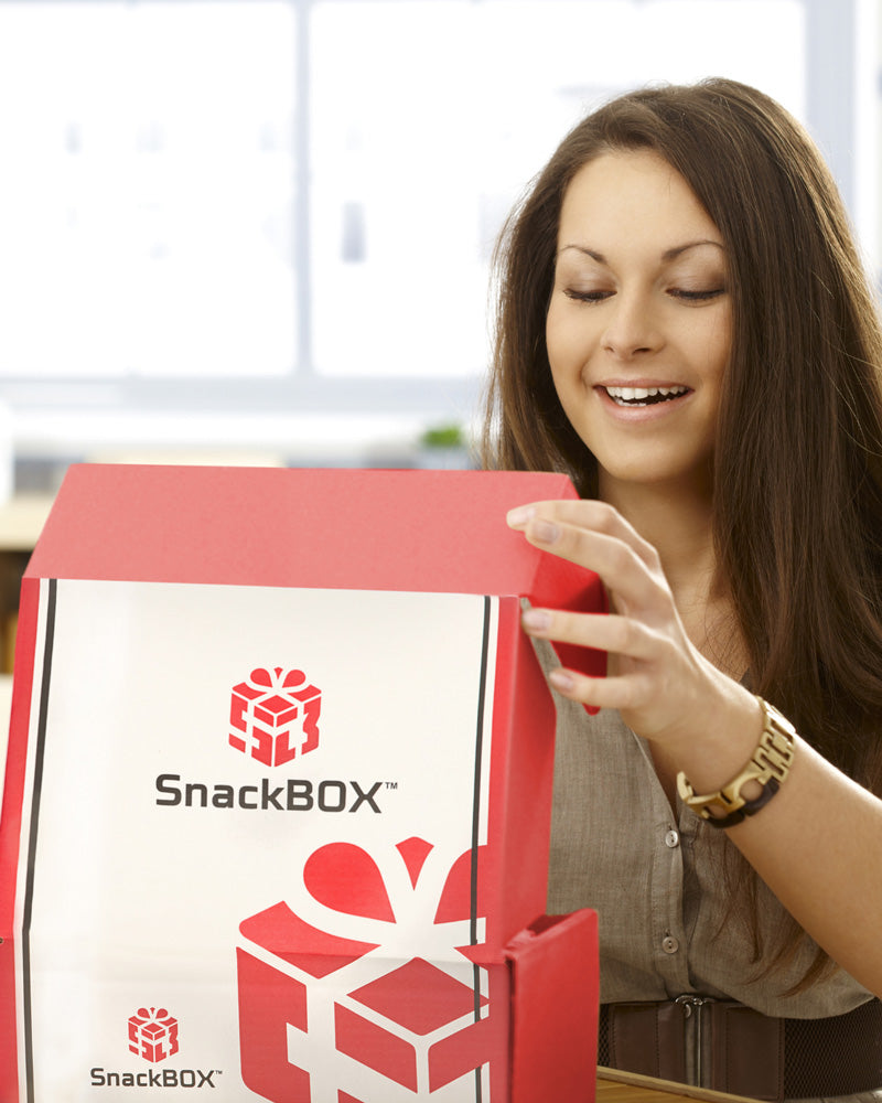 Young woman opening a SnackBox at her kitchen table