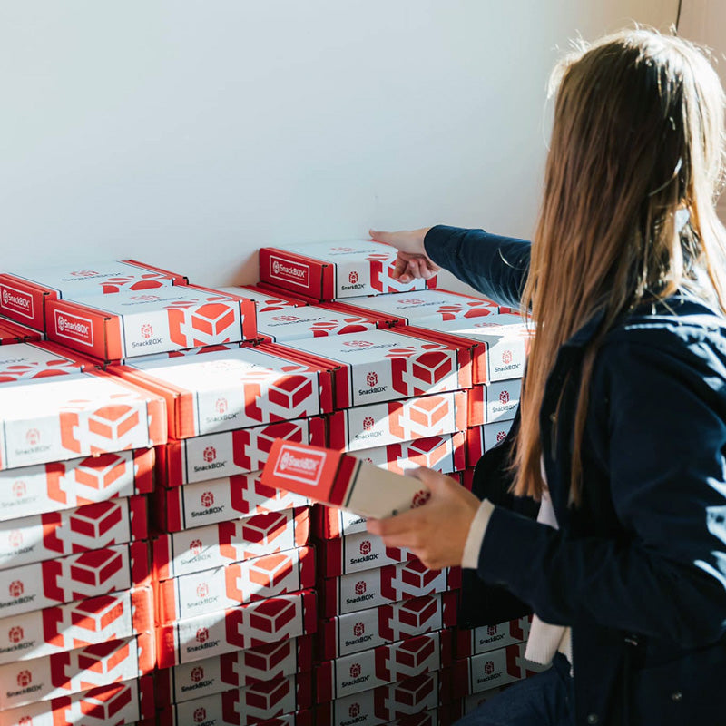 Female employee packing and stacking SnackBoxes in the warehouse